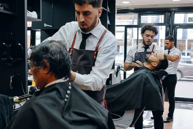 Barbers in aprons at work along the stations