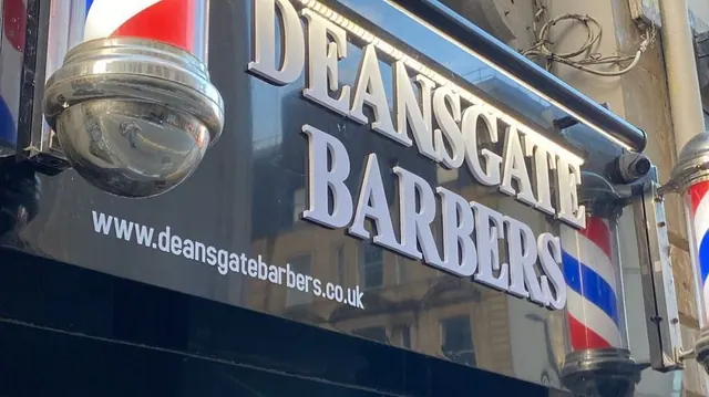 The illuminated Deansgate Barbers sign
